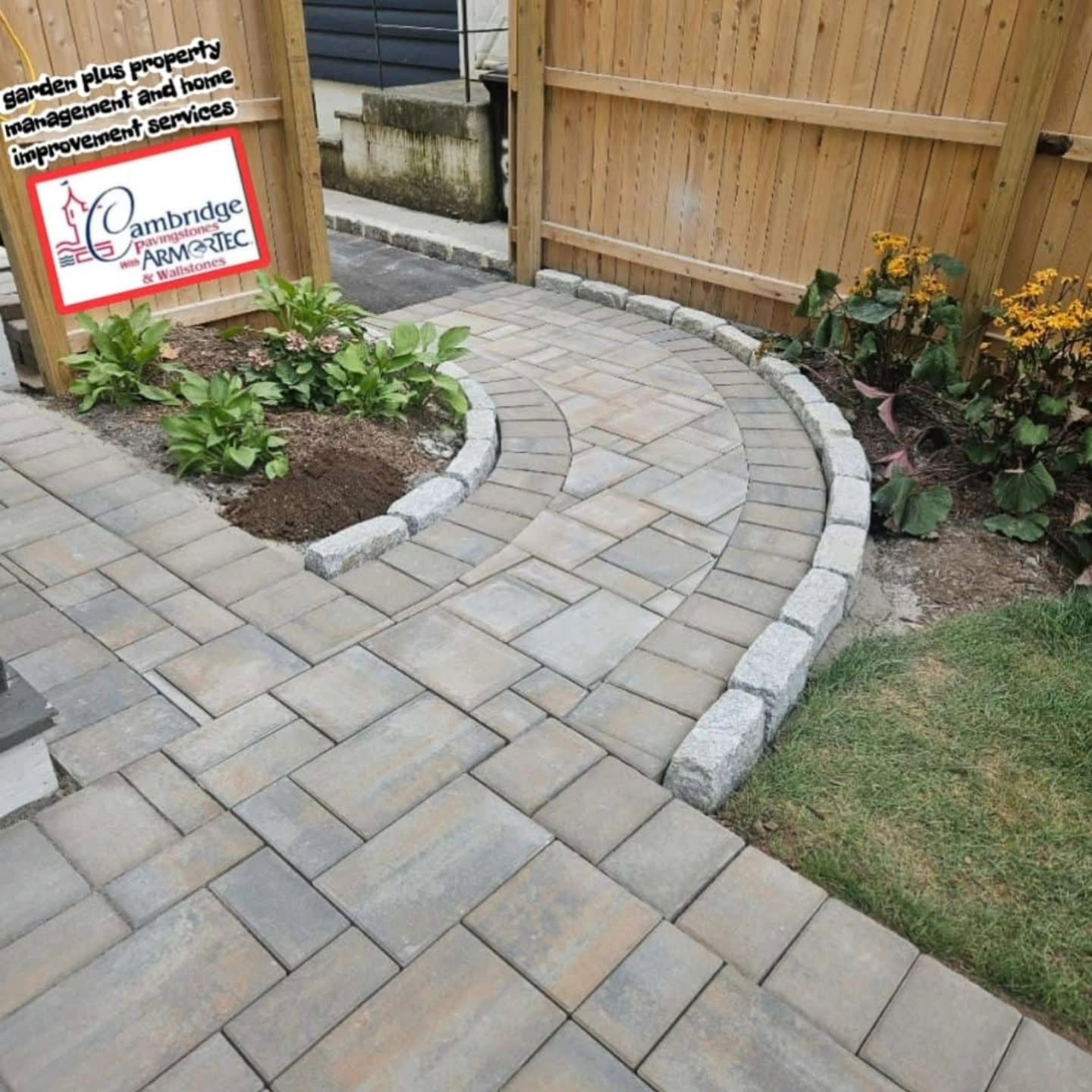 Curved paver walkway with stone edging and landscaped planting bed